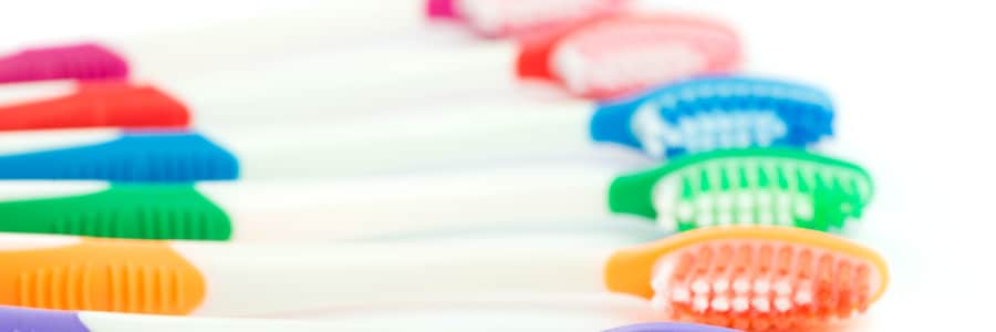 Close up of many types of multicolor toothbrushes on white background